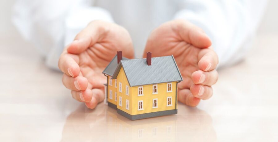 Hands around a miniature home