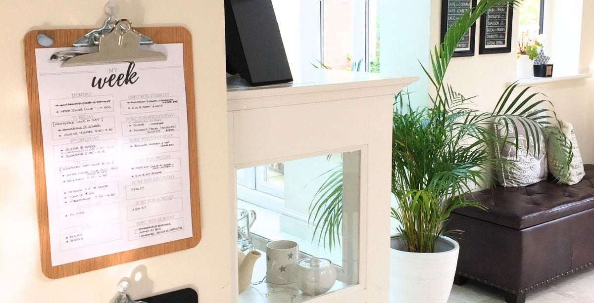 Clipboard on kitchen wall with weekly schedule on