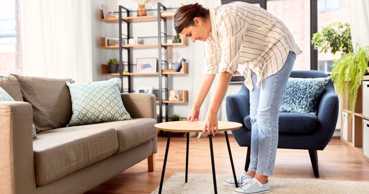 Lady moving things around in her home - making tweaks to the layout