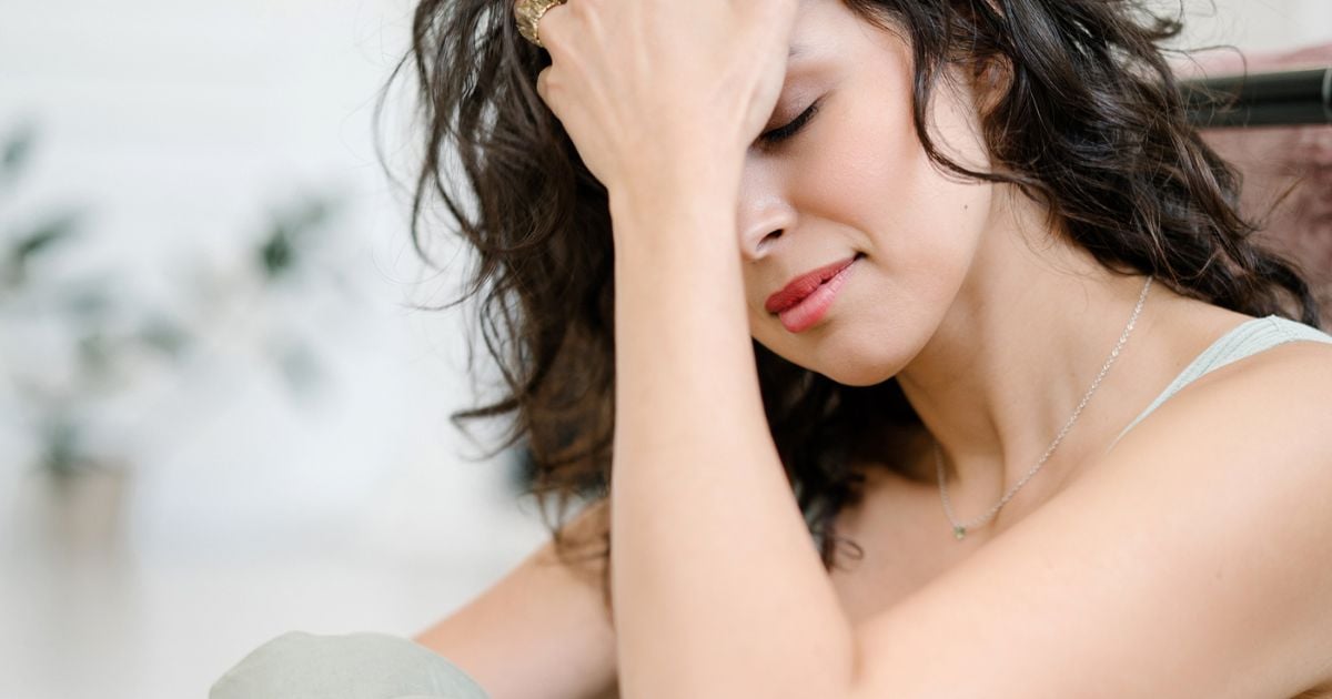 Lady looking upset with her head in her hands