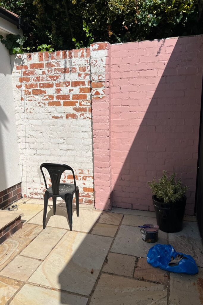 5 Budget-Friendly Steps to Creating a Spring Garden Space You'll Love 6 A white outside brick wall half painted pink