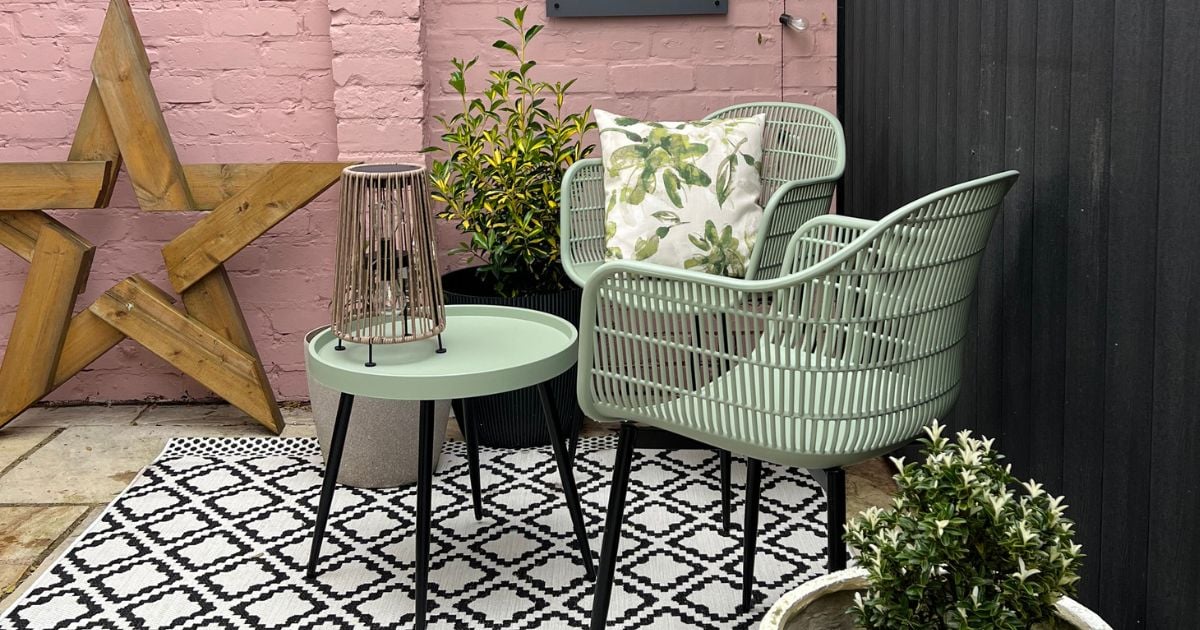 Spring Garden Glow Up of patio area with green seats, black and white outdoor rug, pink wall, and accessories