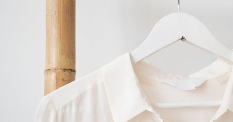 White shirt on white coathanger hanging up on a wooden ladder