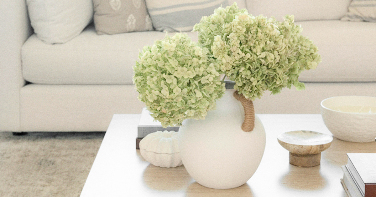 Living room with closeup of coffee table with hydrangeas and books on